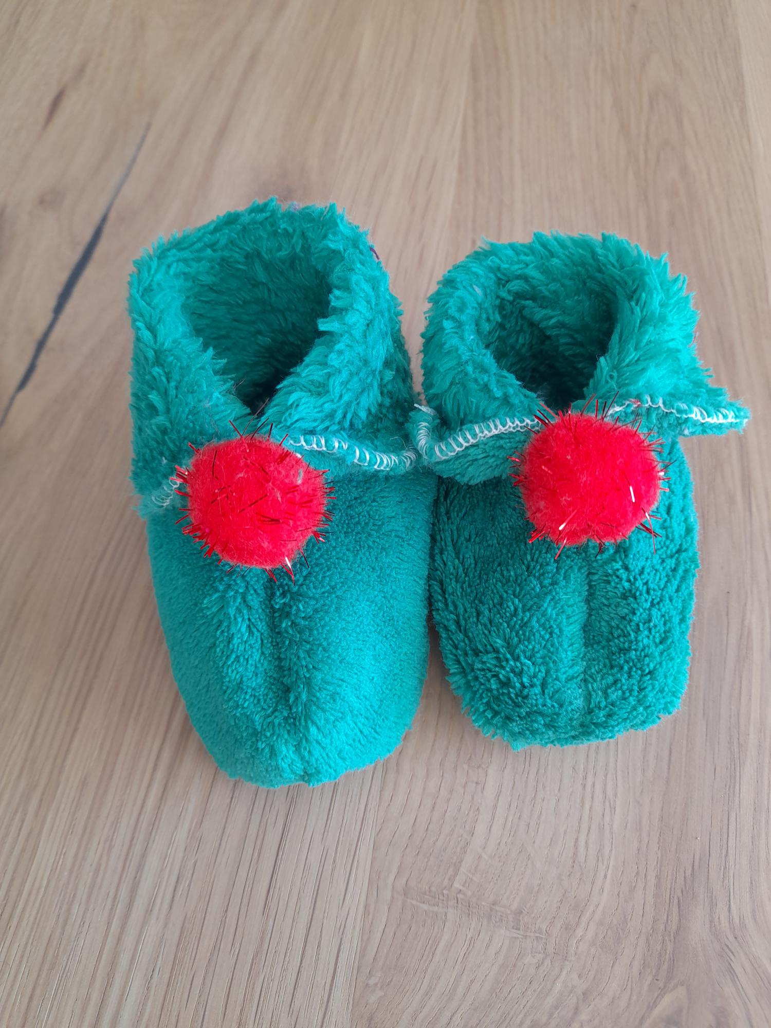 Chaussons bébé verts à pompons rouges